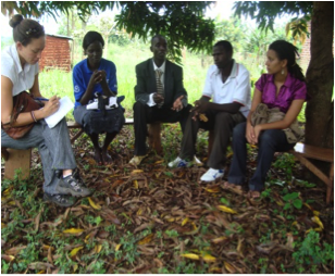 Agnes Akello meets with village officials while other students observe