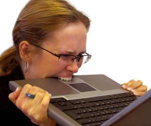 Frustated woman biting laptop